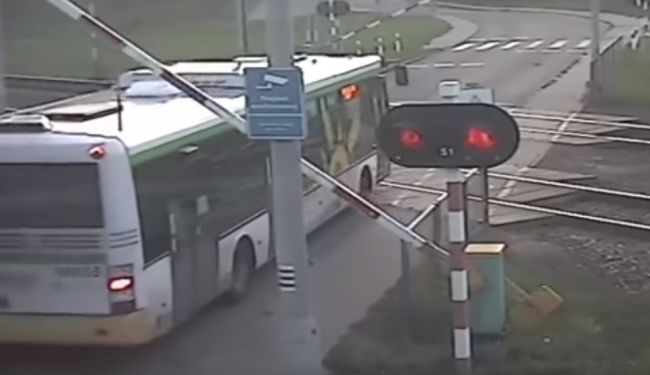 Video: Autobus s cestujúcimi uviazol medzi závorami, vodič nezabránil zrážke s vlakom