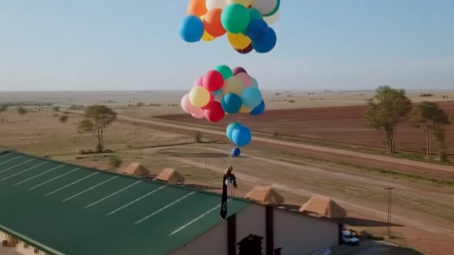 Video: Muž pripevnil 100 balónov na stoličku a vyletel do závratnej výšky