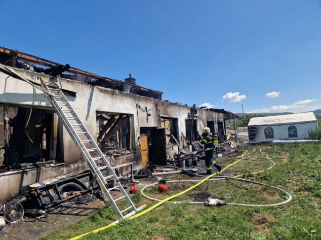 Hasiči zasahujú pri požiari pracovného stroja, oheň sa rozšíril aj na strechu