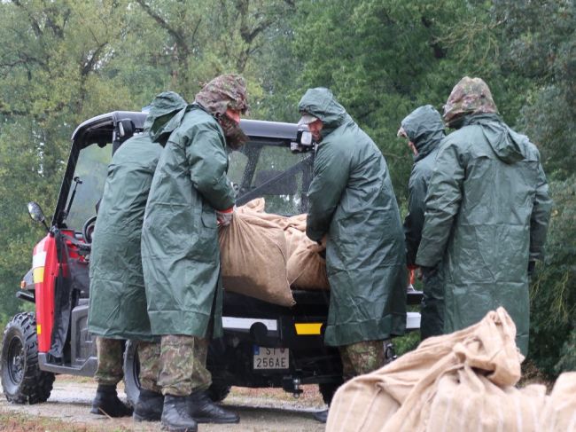 Vojaci pomáhajú s ukladaním vriec s pieskom k hrádzi Moravy