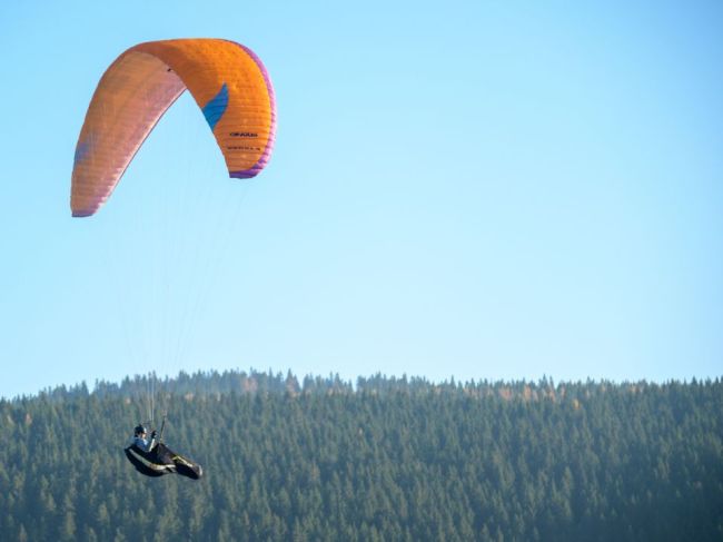 Na strome uviazol paraglajdista, pomáhali mu záchranári